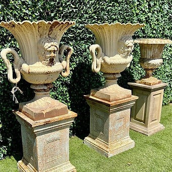 Pair of Cast Iron Urns and Plinths with Snake & Mask Detail